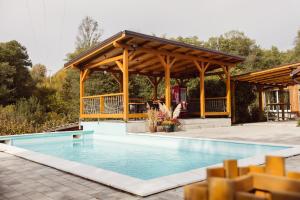 a swimming pool with a pavilion next to a house at Srce Kozare in Prijedor