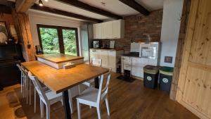 een keuken met een houten tafel en witte stoelen bij Chata z Widokiem in Międzybrodzie Bialskie