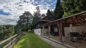 een huis met een houten terras en een tuin bij Chata z Widokiem in Międzybrodzie Bialskie