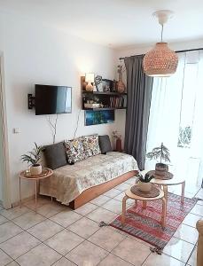 a living room with a couch and two tables at Artemis sea house in Porto Rafti