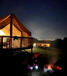 a lit up tent in a field at night at Peaceful Tented Cabin with Fire Pit and Fantastic Sights in Logan, Ohio in Logan