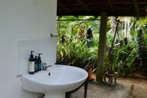 een badkamer met een wastafel met flessen erop bij EcoBlueprint Garden in Pannala