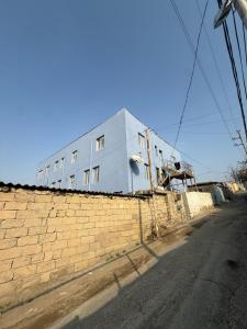 a white building on the side of a brick wall at Rova Hostel in Baku