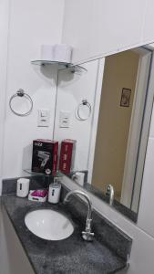 a bathroom counter with a sink and a mirror at Lindo apartamento mobiliado in Ananindeua +2 photos