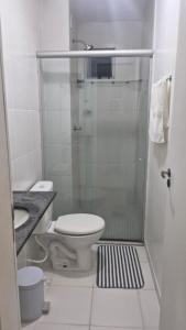 a bathroom with a toilet and a glass shower at Lindo apartamento mobiliado in Ananindeua