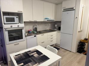 una cucina con elettrodomestici bianchi e un tavolo di Modern & Chic a Vantaa