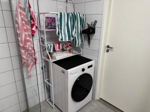 una lavatrice e un'asciugatrice in un piccolo bagno di Modern & Chic a Vantaa