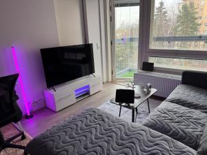 un soggiorno con TV a schermo piatto e divano di Modern & Chic a Vantaa