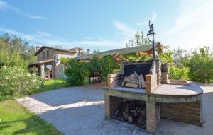 una chimenea de piedra en un patio con una casa en Lake Front Home In Arezzo Ar, en Antria
