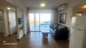 Una sala de estar con un sofá y un refrigerador. en Beit Nofesh, en Tiberíades