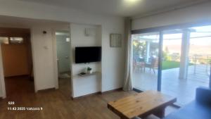 sala de estar con TV y mesa de madera en Beit Nofesh, en Tiberíades