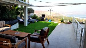 un patio con césped, mesa y sillas en Beit Nofesh, en Tiberíades