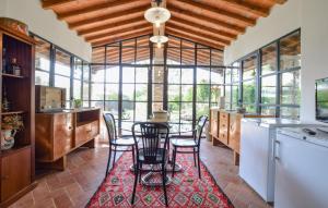 una cocina con mesa y sillas sobre una alfombra roja en Lake Front Home In Arezzo Ar, en Antria
