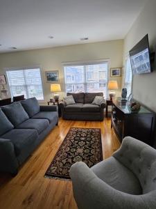a living room with two couches and a tv at Second Row Stunning Ocean and Marsh Views in Holden Beach