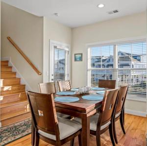 a dining room with a wooden table and chairs at Second Row Stunning Ocean and Marsh Views in Holden Beach