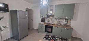 a kitchen with gray cabinets and a refrigerator at B&B Fior di Feruci in Trenta