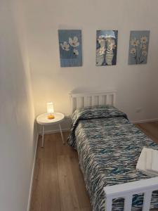a bedroom with a bed and a table and paintings on the wall at B&B Fior di Feruci in Trenta