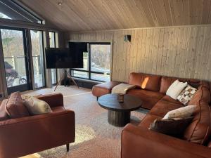 a living room with two couches and a tv at New modern cabin in Beitostølen in Beitostøl