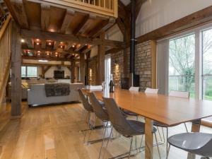 Un comedor con una gran mesa y sillas de madera. en Coot Lodge, en Somerford Keynes
