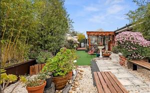 a garden with a wooden bench and some plants at Home of Susan Close in Narre Warren