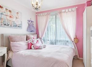 a pink bedroom with a teddy bear sitting on a bed at Home of Susan Close in Narre Warren