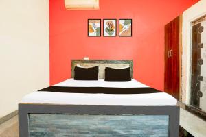 a bed in a room with a red wall at Hotel O AnubhavRooms in Etāwah