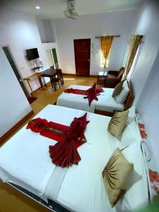 two beds in a hotel room with red decorations on them at Hassana Garden Home in Ko Lanta