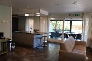 a kitchen and a living room with a couch and a table at La Bordure de la Forêt in Sourbrodt