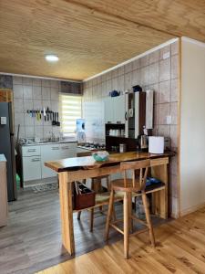 a kitchen with a large wooden table in a room at Cabañas Campo Frutillar in Frutillar +20 photos