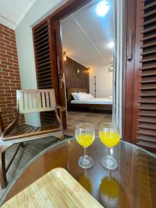 Dos vasos de jugo de naranja sobre una mesa en Aethera Stay, en Mirissa