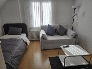 una sala de estar con un sofá y una mesa en Central studio apartment gratis Parkplatz, en St. Gallen