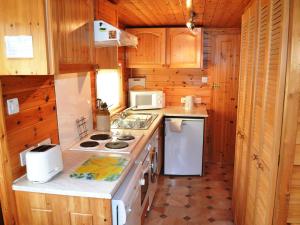a small kitchen with a stove and a microwave at Ashness in Keswick
