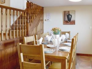 Un comedor con mesa y sillas de madera. en Ty Hir Bwlch Gwyn Farm Equestrian Centre, en Fairbourne