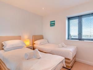 een kamer met twee bedden en een raam bij 10 Horizons in Newquay +9 foto's
