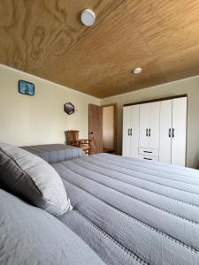 a large bed in a bedroom with a wooden ceiling at Cabañas Campo Frutillar in Frutillar