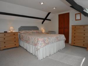 a bedroom with a bed with a dresser and a dresser at Barrowmead Cottage - E2377 in Banwell