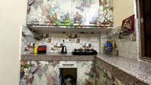 a kitchen with a counter top with tiles on the wall at Varanasi Bliss Stay in Varanasi