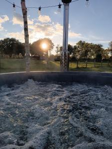 a large pool of water with the sun in the background at Monteurwohnung, Ferienwohnung auf dem Land in Gokels