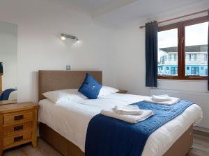 a bedroom with a bed with towels on it at Coot in Wroxham