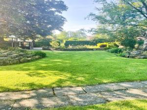 einen großen Garten mit grünem Rasen in der Unterkunft Owl Cotes Cottage in Cowling