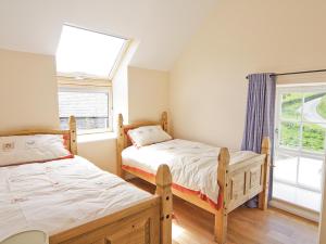 a bedroom with two beds and a window at Smithy Barn - Hw7592 in Bettws-yn-Rhôs