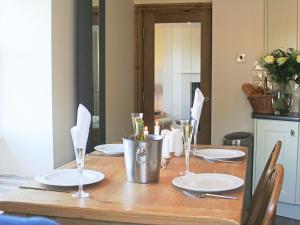 BurlescombeにあるWerescote Viewの皿とワイングラスが置かれた木製のテーブル