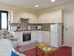 a kitchen with white appliances and a table at Carol's Cottage - E3043 in Blyford