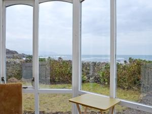a room with windows looking out at the ocean at Shore Cottage in Bellochantuy
