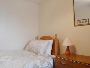 een slaapkamer met een bed, een lamp en een dressoir bij Ross Cottage in Cairneyhill +9 foto's