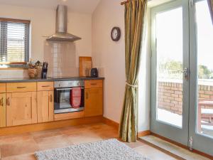 een keuken met een fornuis bovenste oven naast een raam bij The Wests in Lastingham