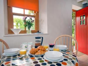 een tafel met een ontbijt van croissants en jus d'orange bij Ria's Cottage in Landshipping