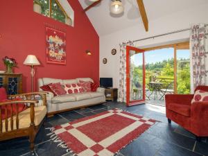 een woonkamer met rode muren en een bank bij Ria's Cottage in Landshipping