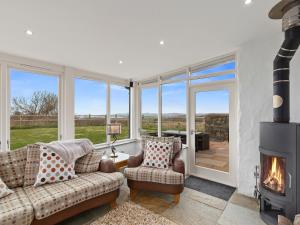 ein Wohnzimmer mit Couch und Kamin in der Unterkunft Temple Barn in Abercastle
