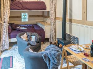 a living room with two chairs and a bed and a stove at Jacobs Folly-Qu7115 in Melton Constable